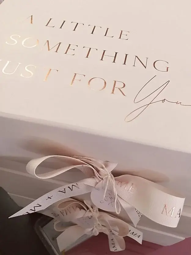 The box the hampers comes in complete with ribbon close and a rose gold foil " A little something just for you" message