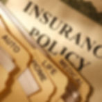 Files labeled "Auto," "Home," "Life," and "Medical" on folders, with "Insurance Policy" document beneath, in warm lighting.