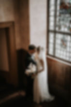 Bride and groom by a stained glass window in Edinburgh.