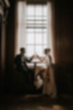 Bride and groom toasting at a window in Edinburgh.