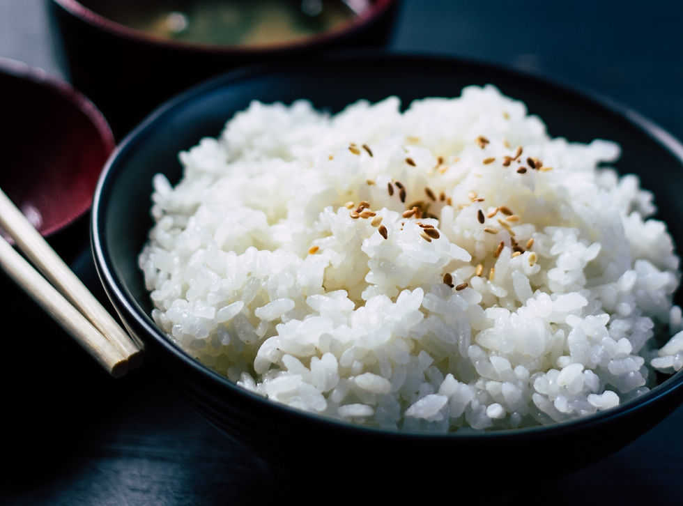 Close-up of freshly cooked Japanese sushi rice, slightly glossy and gently clumped, highlighting its soft texture and subtle stickiness.