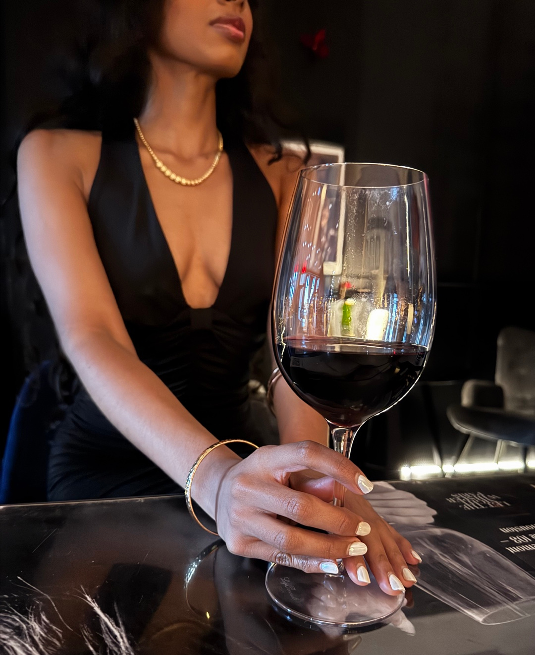 A hand holding a glass of red wine at Château Bellecru.