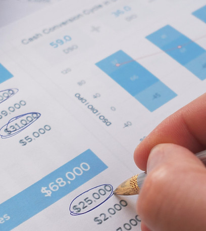 A hand skillfully annotates a variety of financial documents using graphs that effectively