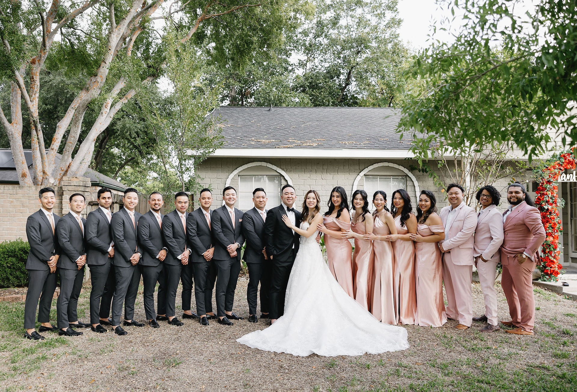 wedding party with bridesmaids in pink and groomsmen in black