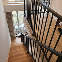 Industrialna balustrada harfa z czarnej stali przy betonowych schodach w mieszkaniu w Radomiu