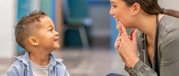 Client is engaged in the therapy looking at the visual a tactile prompts provided by the therapist.