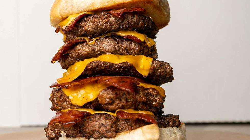 Delicious triple-stacked bacon cheeseburger with melted cheese, perfect for food lovers.