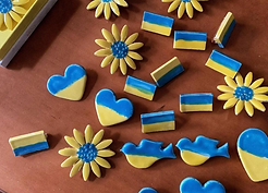 Pins in the shape of hearts, rectangles, and sunflowers, made of ceramics and colored in the colors of the Ukrainian flag. 