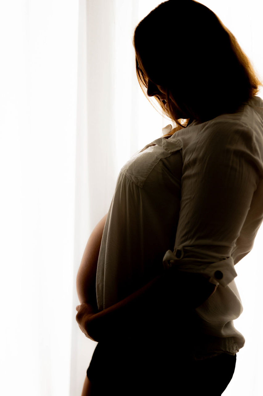 Babybauchshooting Bad Saarow - die schwangere Frau hält ihren Babybauch