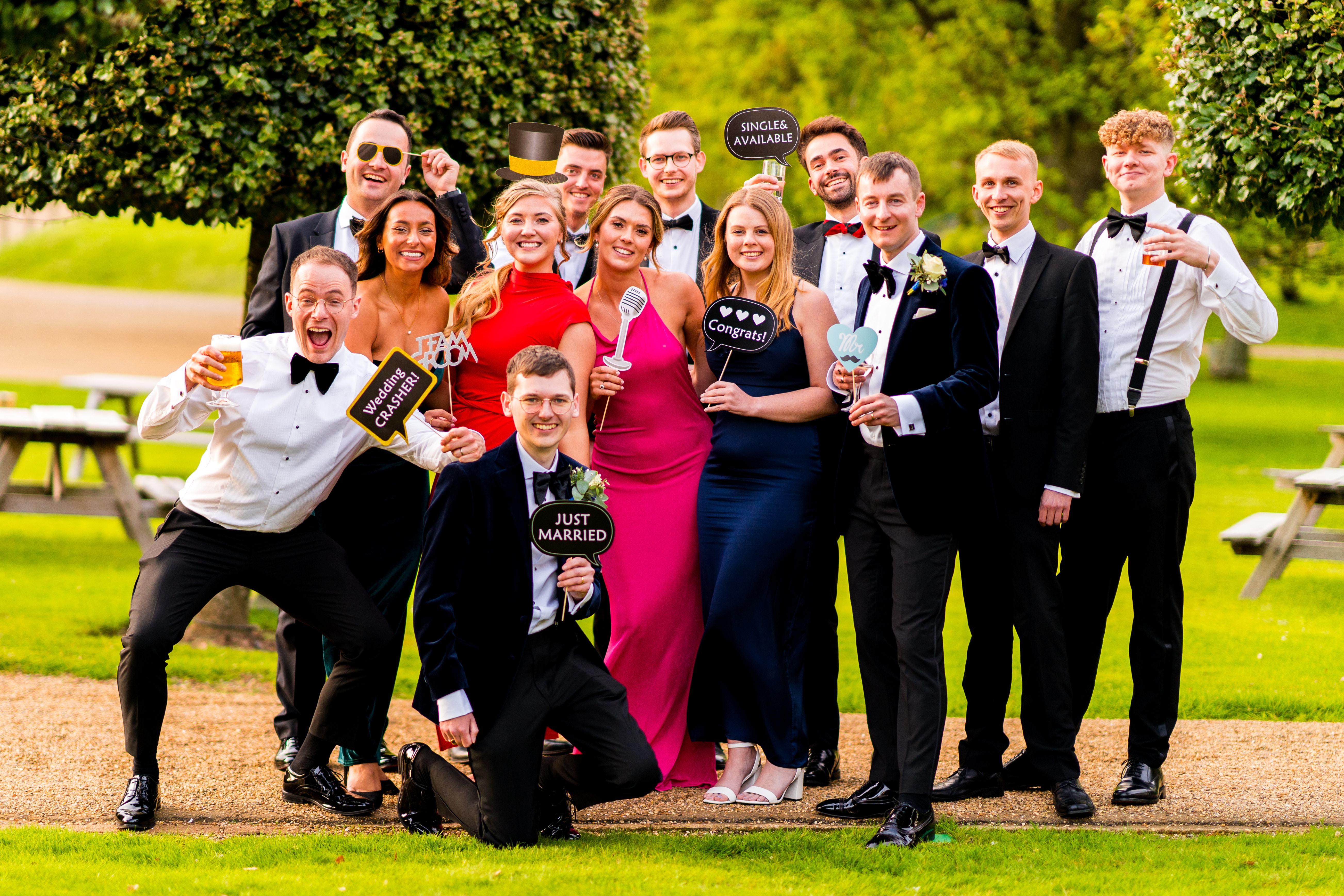 wedding guests posed outside holding signs up