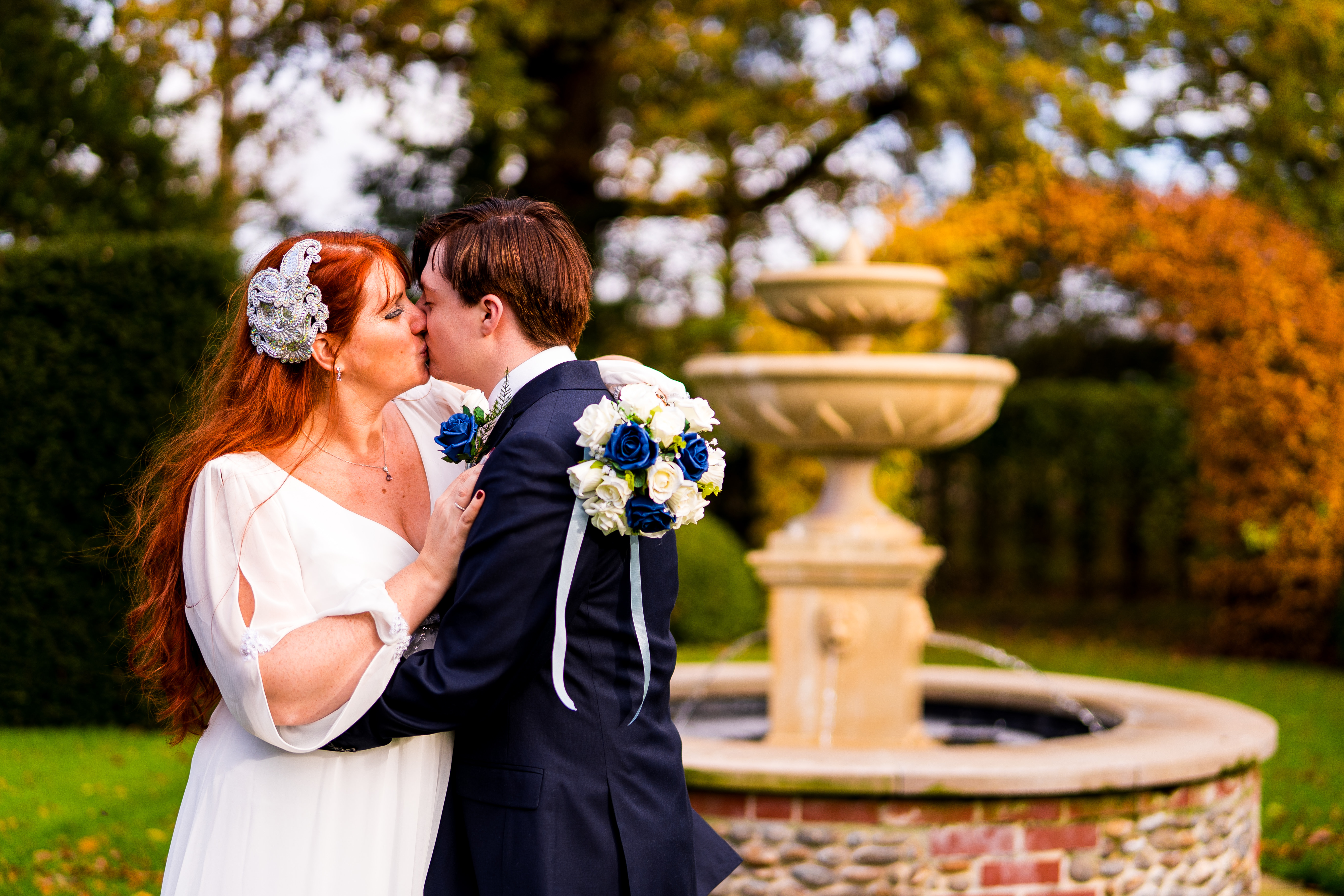 bride and groom kissing outside in front of water fountain