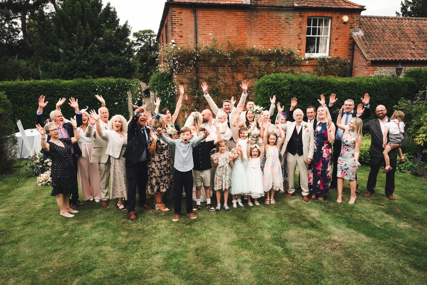 wedding guests outside with arms in the air