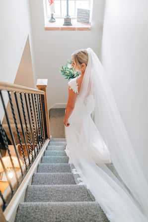 bride holding flowers 
walking down stairs inside