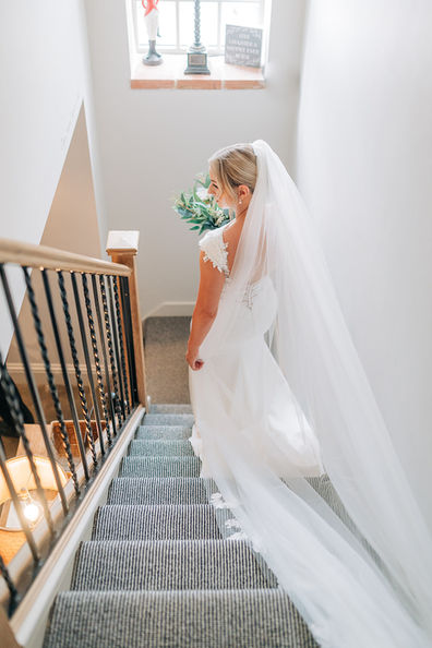bride holding flowers
walking down stairs inside