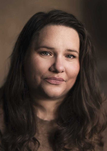 Glad kvinna med långt mörkt hår som tittar in i kameran - Porträttfotografering av Fotograf Isa Ciscar Thunberg i Vingåker och Katrineholm