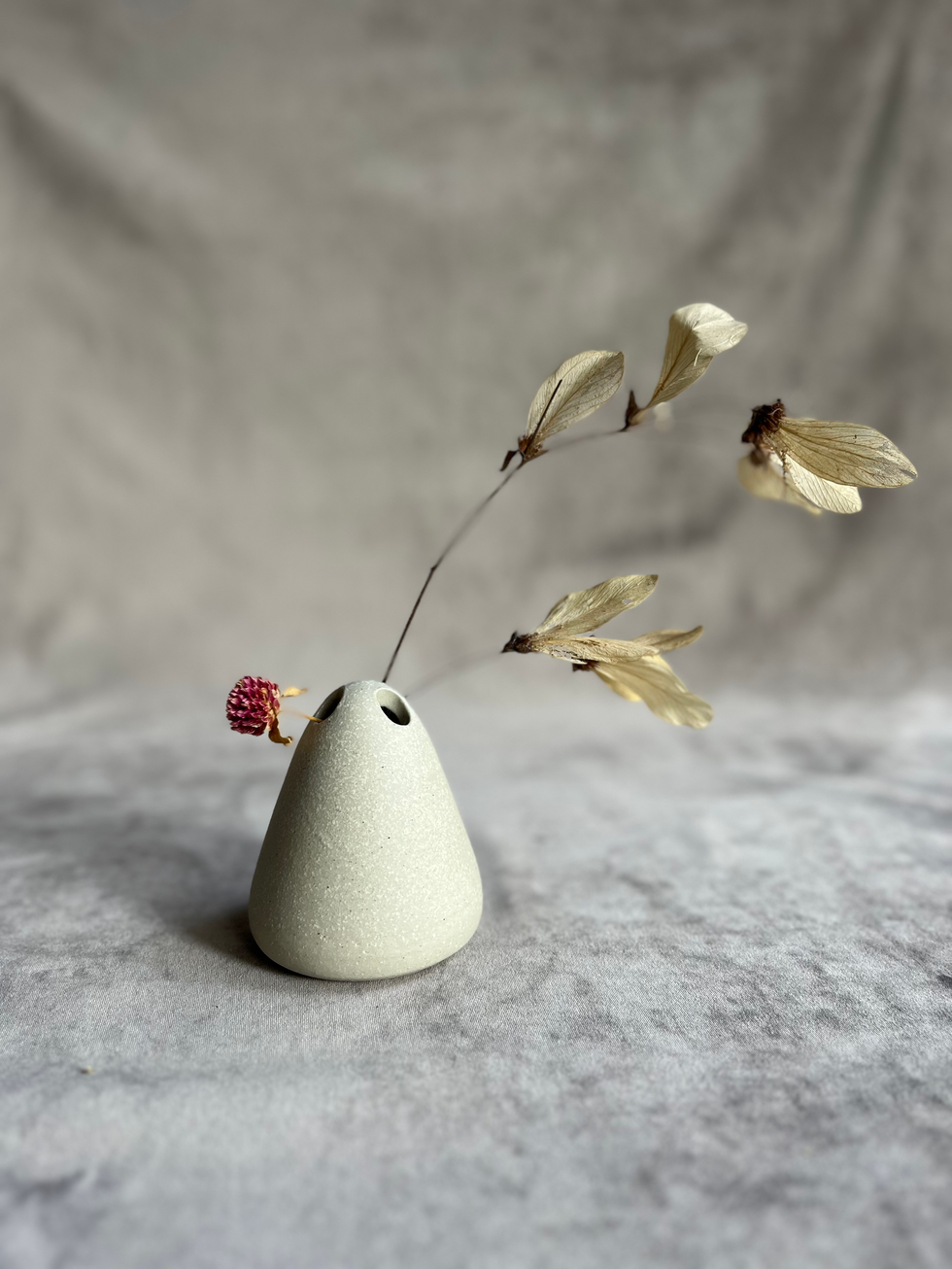 Vaso para 3 flores solitárias feito à mão, no torno, em cerâmica de alta temperatura na cor off-white.