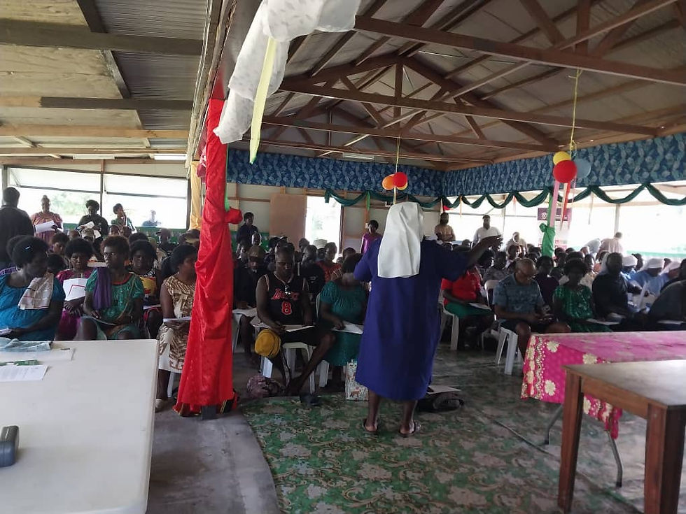 Sr. Lorraine Garasu addresses community-based actors from across Bougainville, explaining the forum's theme during a gathering in a decorated hall.