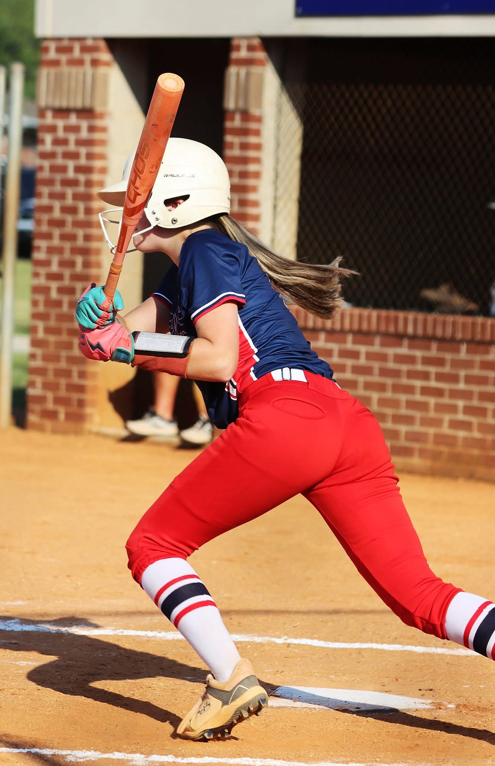 Softball player swinging a bat during a game