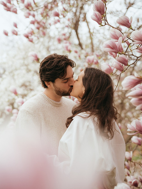 a couple taking portraits in the cherry blossoms new york