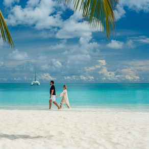 Couple walking on a beach at one of the best beach honeymoon destinations in the world.
