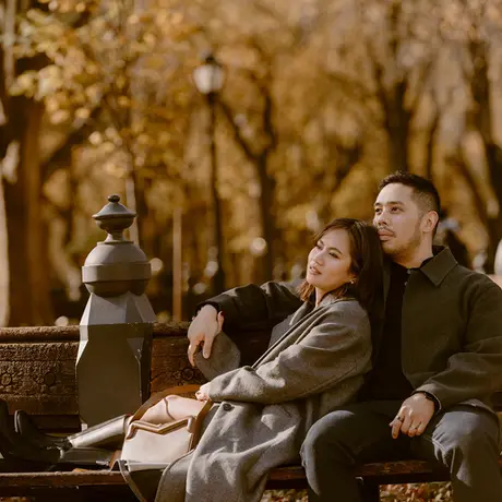 couple sitting on a bench for their Fall photoshoot in Central Park