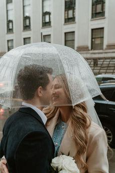 Rainy day photos in NYC with a couple kissing with umbrella