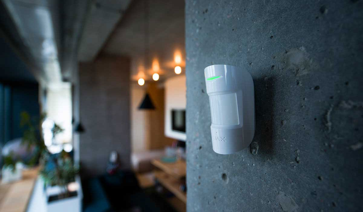 White motion sensor on a concrete wall, home security.