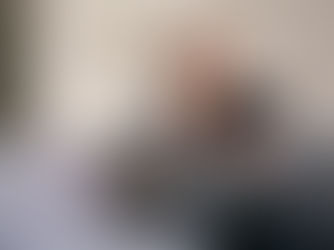 A lady sat on a grey sofa holding a tablet device