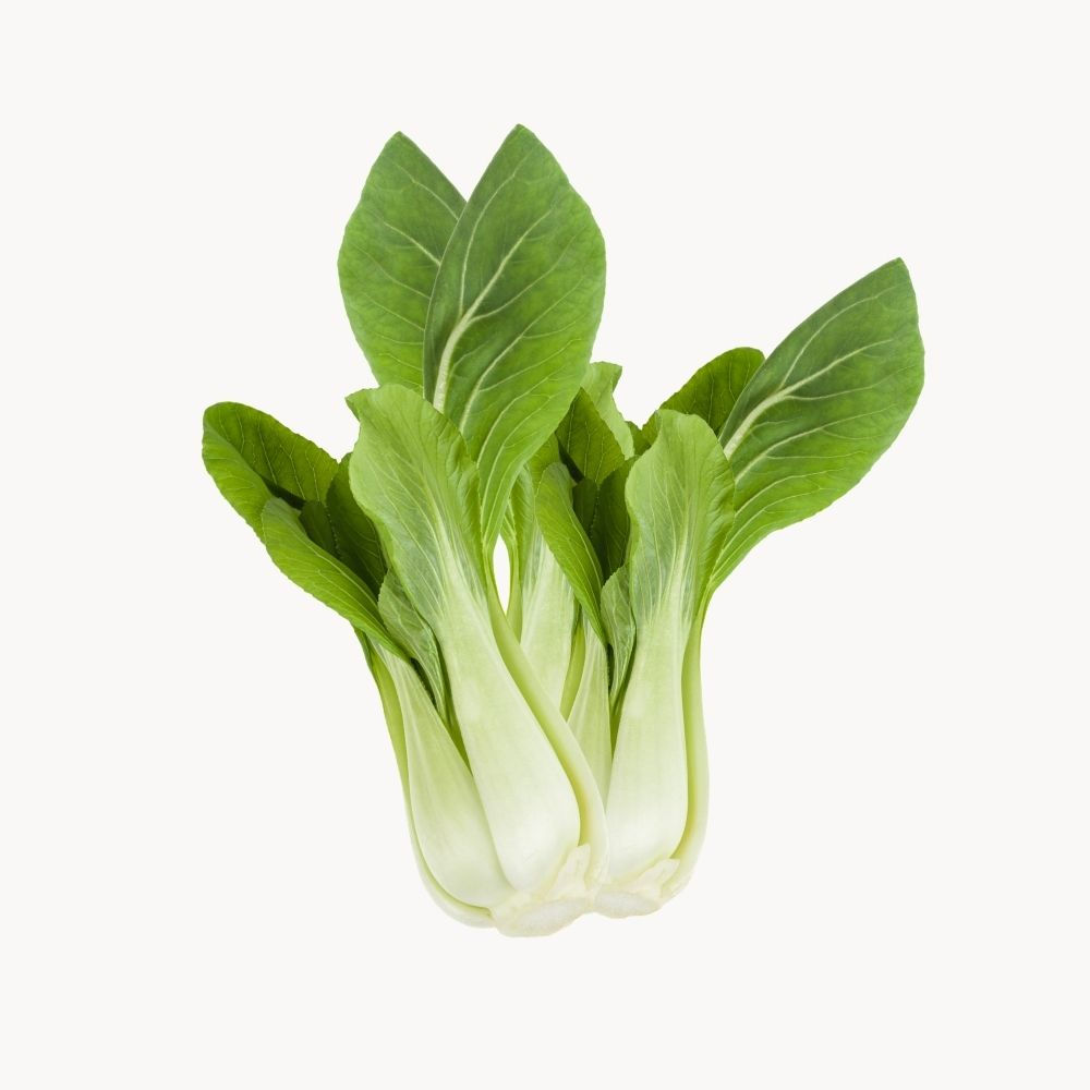 A bunch of bok choy on a cream background