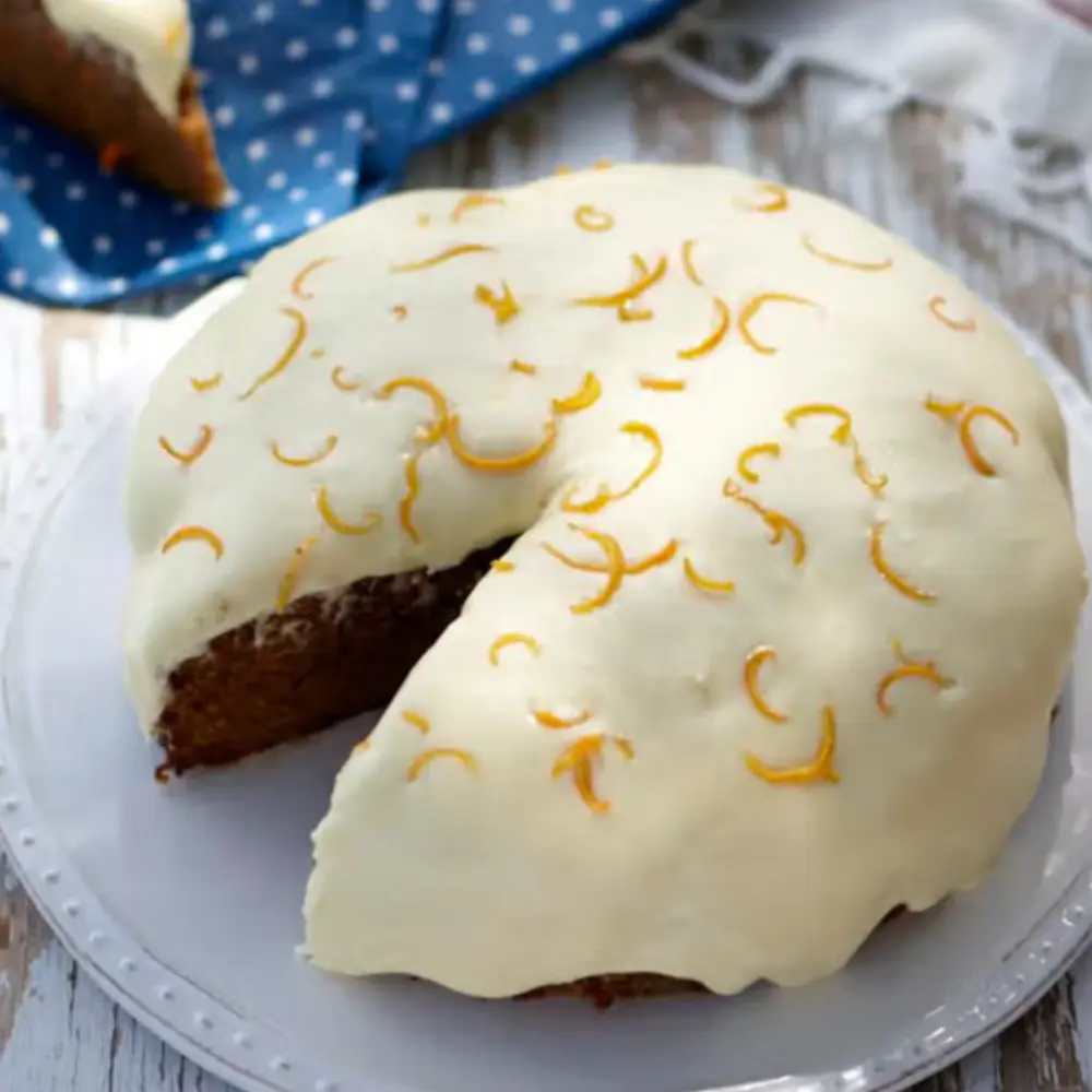 Carrot cake with cream cheese icing and lemon zest decoration