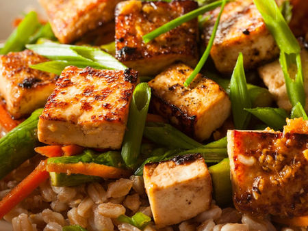 Crispy tofu on a bed of asian greens and rice