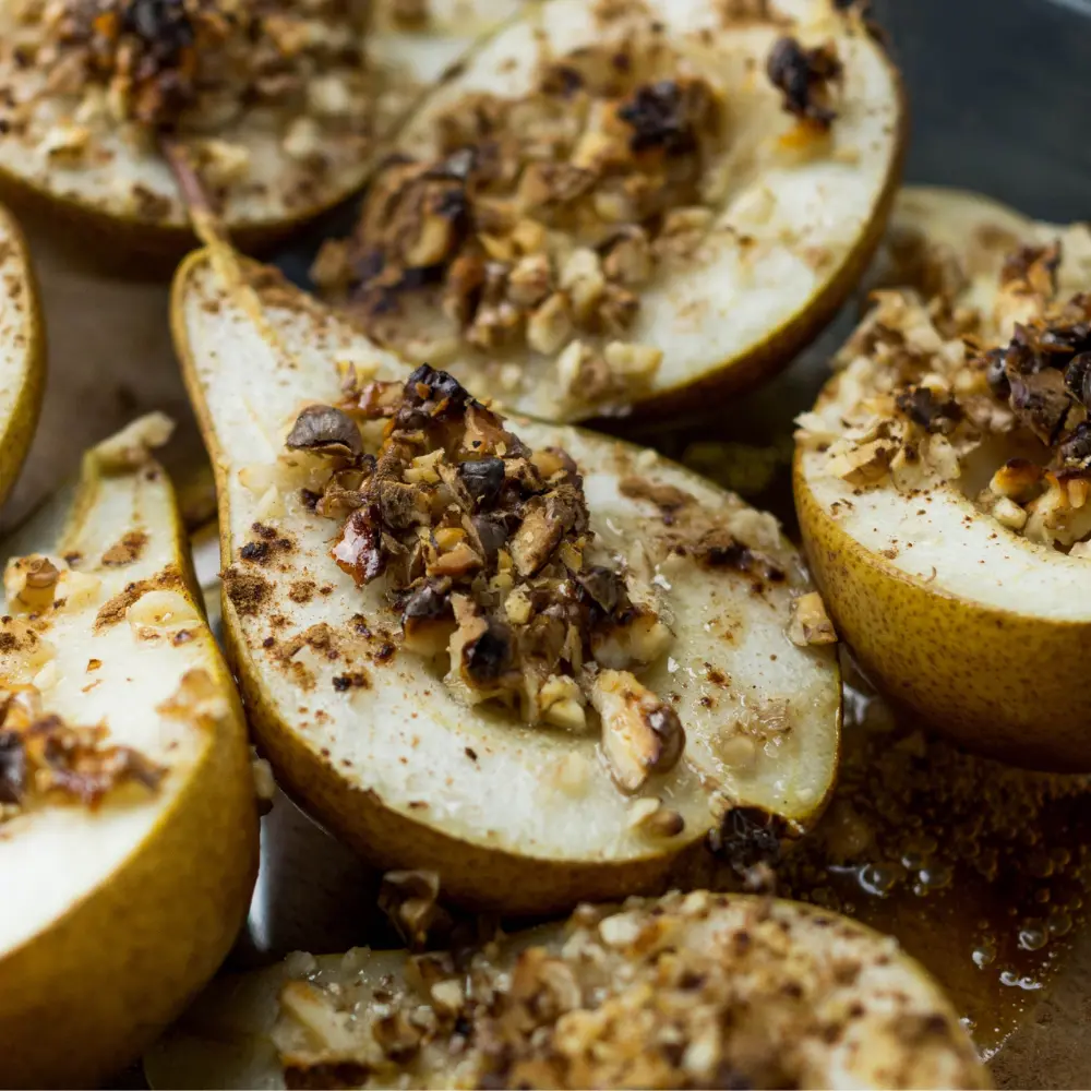 Halved baked pears with walnuts on top