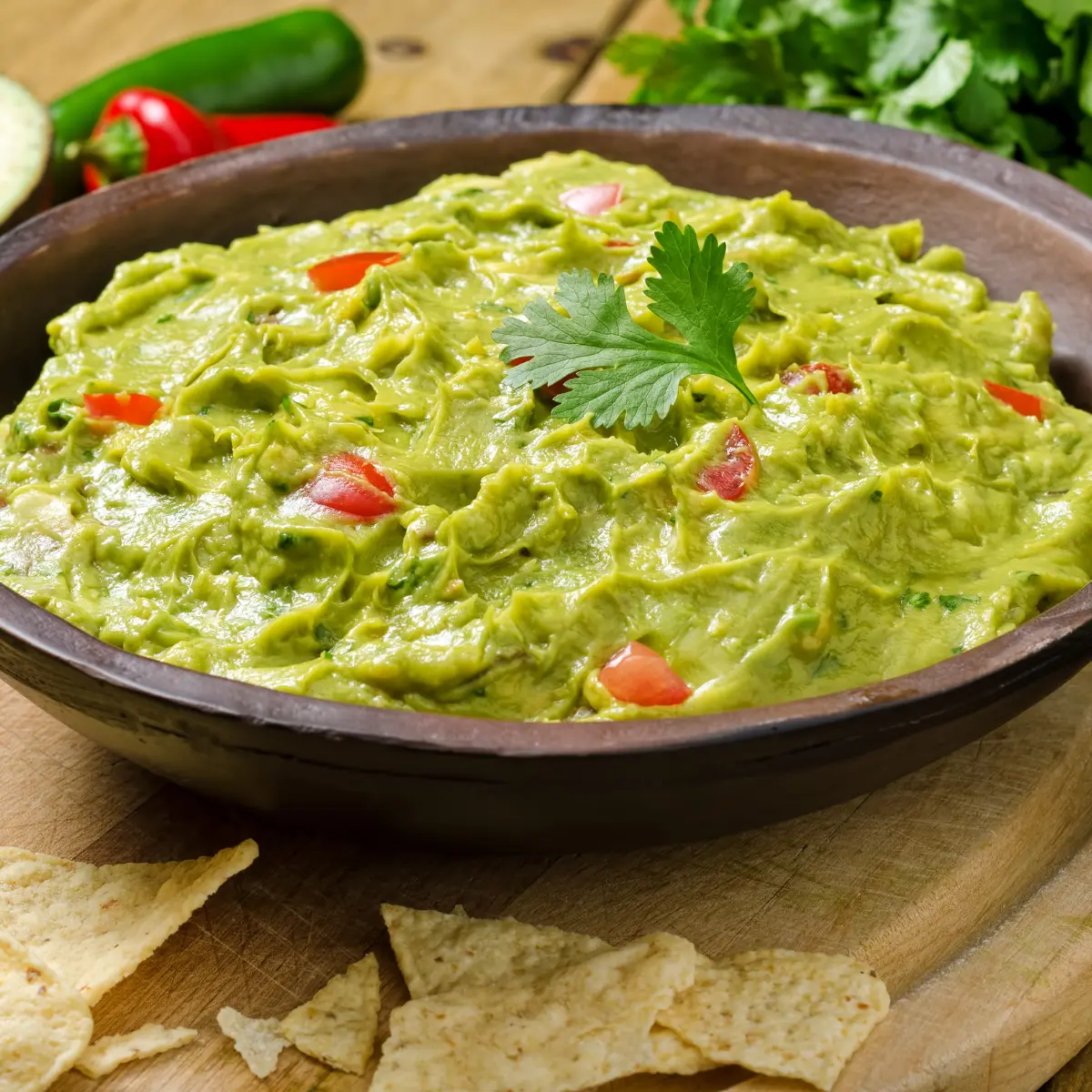 A bowl full of creamy guacamole topped with coriander