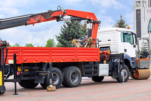A truck with a hydraulic crane stands in the parking lot of a construction exhibition_