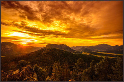 Golden sunset over Rocky Mountain wilderness landscape with vibrant orange sky, evergreen forest, and panoramic mountain vista - perfect for nature photography, outdoor adventure, and hiking destination inspiration.