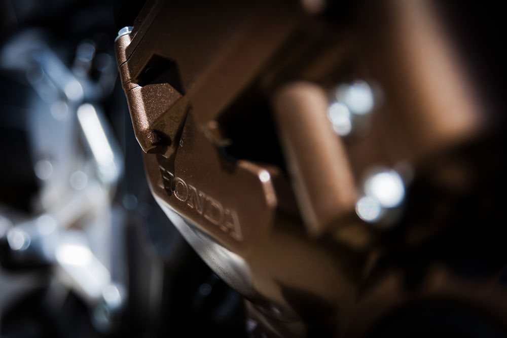 Honda CB650R részletfotó barna motorelemmel és Honda felirattal, harmonikus motor háttérrel