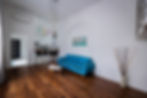 Airbnb nappali természetes fényben, ablakok mellől fotózva.