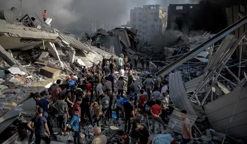 Civis observam prédio destruído por bombardeio israelense em Jabalya, na Faixa de Gaza. Foto - Omar El-Qattaa / AFP