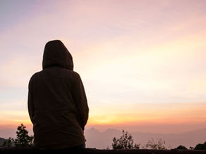 young man walking alone at sunset