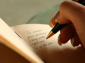 woman writing cursive in a journal