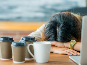 woman with her head down on her desk tired and frustrated