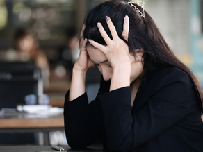 woman in a toxic workplace holding her head out of frustration
