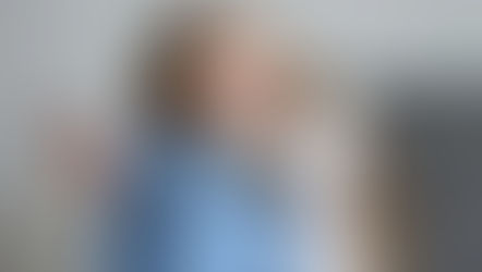 woman with her head on her knees holding her phone