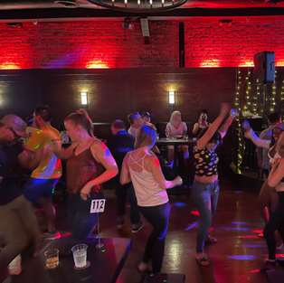 Crowded bar scene at Derwolf Pasadena during Taco Tuesday with guests eating tacos and enjoying karaoke.