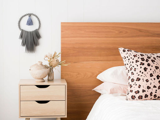 Soft neutral bedroom styling with layered linen bedding, cushions and natural light