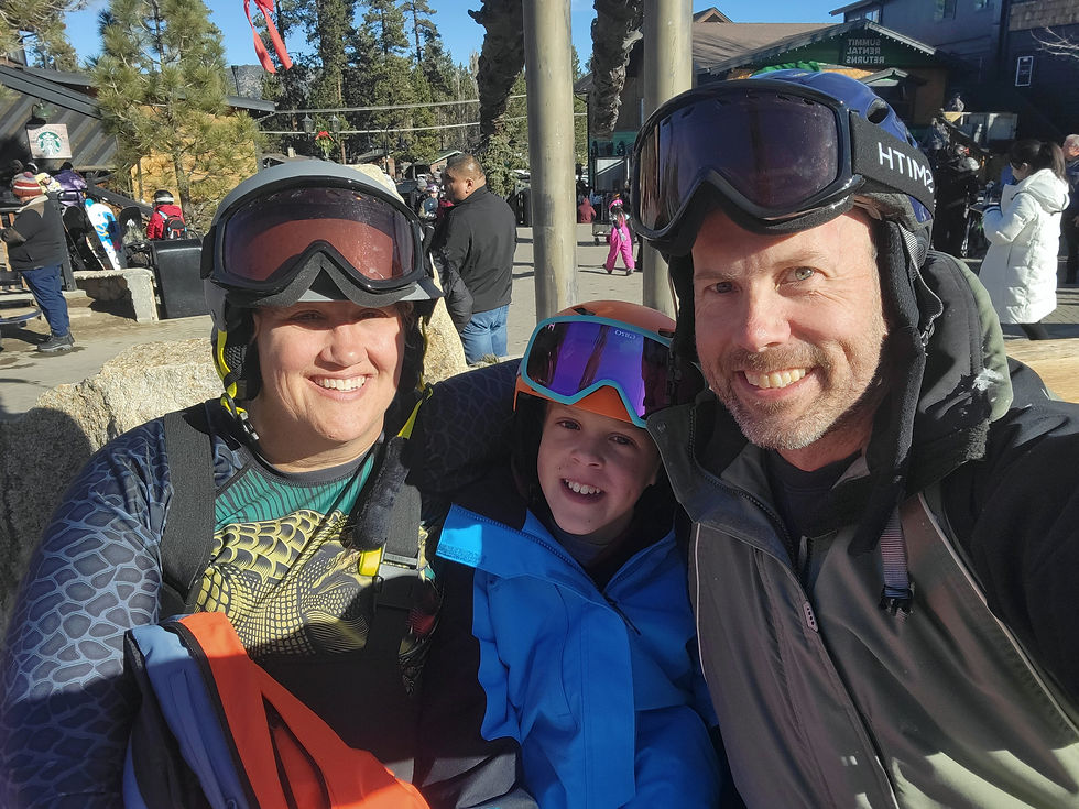 Middle-Aged Couple in Ski Clothes, Including Helmets and Goggles, with Tween Son, posing together for a Selfie