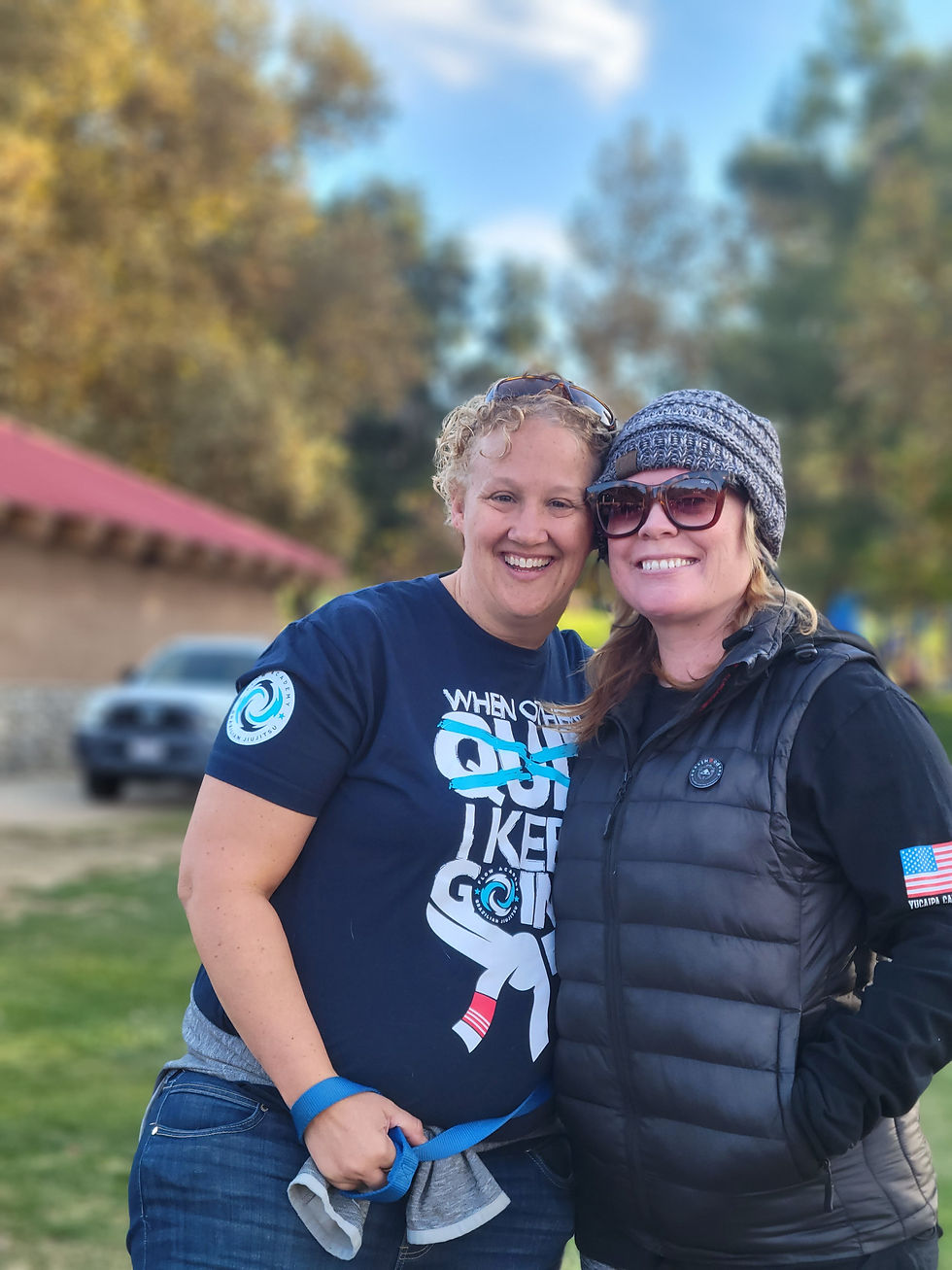 2 women, smiling and posing, at a park