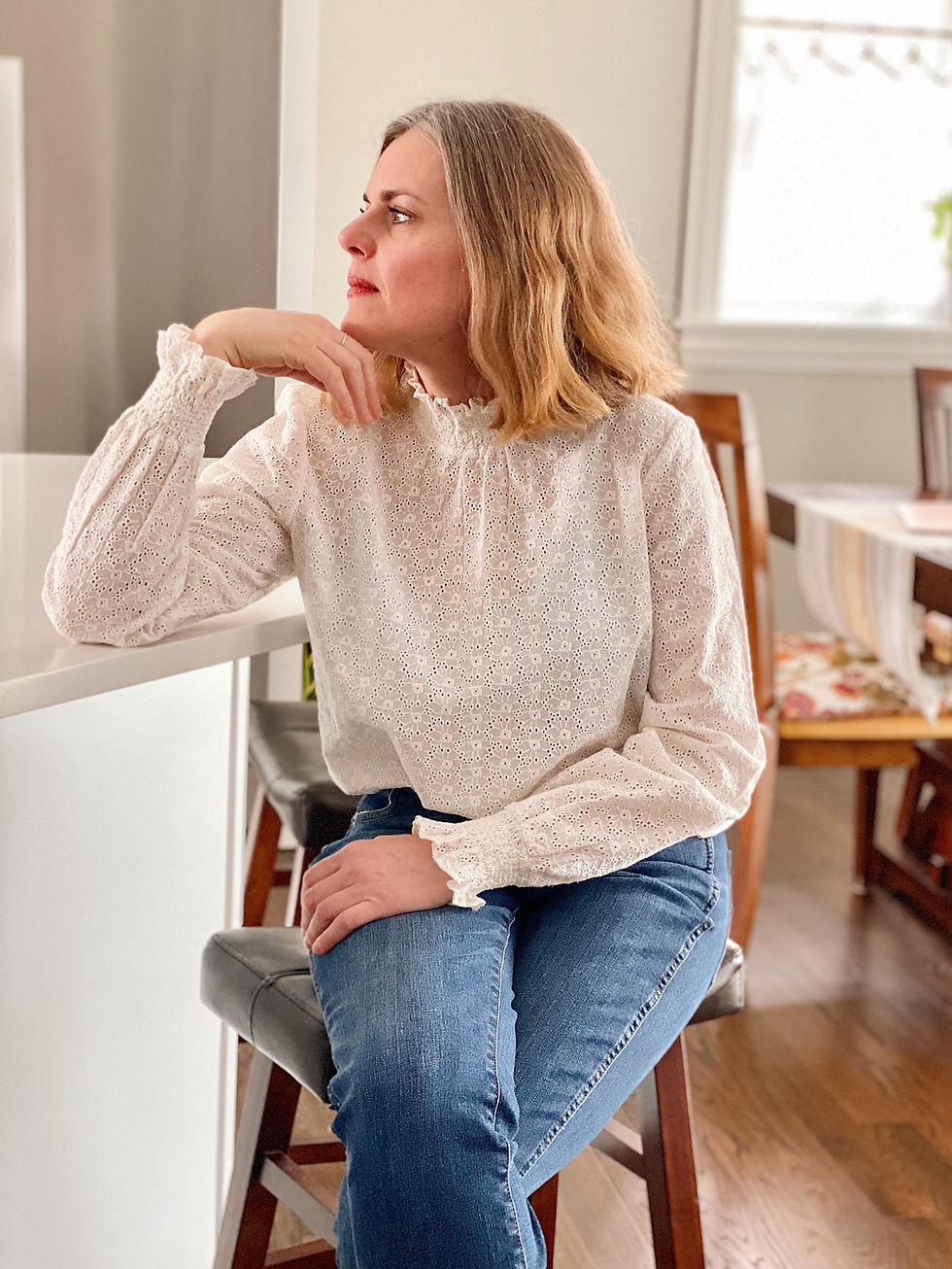 blond woman sitting on a stood in deep thought
