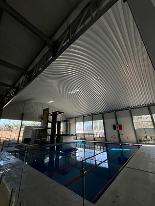 Alberca dentro de un arcotecho que brinda espacio, diseño y resistencia.