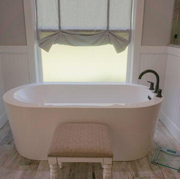 Residential bathroom featuring freestanding soaking tub and decorative tile accents